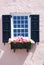 Charming pink building with window and black shutters and planter box in Charleston, South Carolna.