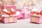 Charming Pink Christmas Gift Boxes with Gold Bow on Festive Defocused Holiday Background.