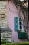 Charming pink cottage with a blue rounded shutter by a window with window box.