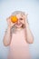 Charming plump curly blonde in pink dress with orange on white solid studio background alone