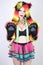 Charming plus size young woman in fur hat made of multicolored fibers with cat ears and paws posing in green suspenders, black bra