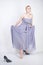 Charming plus size young woman in grey gown dress lost slipper on white background in Studio. beautiful chubby short hair blonde g