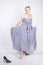 Charming plus size young woman in grey gown dress lost slipper on white background in Studio. beautiful chubby short hair blonde g