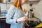 Charming pregnant redhead woman cooking spagetti in kitchen