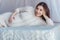 Charming pregnant woman lying on a bed with canopy at home