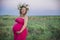 Charming pregnant woman with a wreath in the field