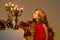 Charming Preteen Girl Blowing out Candles in Vintage Chandelier