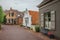 Charming and quiet street with brick rustic houses and greenery in cloudy day at Drimmelen.