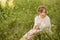 Charming sensual young woman sitting on grass with dandelions