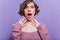 Charming shocked girl with big dark eyes posing on purple background. Spectacular young lady with short curly hairstyle