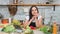 Charming smiling female housewife posing at kitchen during cooking fresh appetizing vegetable meal