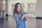 Charming smiling happy woman dressed in jeans shirt is drinking latte while doing shopping in a mall takeaway coffee shop to go wa