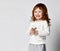 Charming smiling red-haired little girl in sportswear studio shot