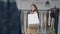 Charming smiling woman with shopping bags on shoulder standing in shop looking away. Positive satisfied Caucasian buyer