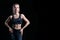 Charming sportswoman posing in the studio on a black background. The concept of bodybuilding, fitness, stretching, healthy eating