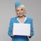 Charming stewardess holding empty white paper banner in her hands.