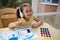 Charming talented Caucasian child paints with watercolors, a cheerful little cute girl plays and learns to paint colors