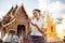 A charming Thai woman in a traditional Thai-Lanna dress is admiring a beautiful garland in her hand