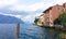 Charming view of an old European city above a mountain lake. Postcard with a view from the pier on the embankment of the Italian