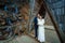 Charming wedding couple kiss on the wooden bridge in mountains. Waterfall background
