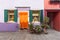 Charming and well-kept yard full of flowers with a colorful facade, decorative wraps and doors