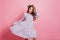 Charming white girl playing with purple dress while posing in flower wreath. Indoor photo of interested lady expressing