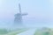 Charming windmill in dense fog