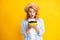 Charming woman with cherry plate isolated on yellow.