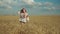 Charming woman enjoying walk in wheat field at sunset