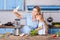 Charming woman and little girl taking selfie in modern kitchen, holding bowl of vegetable salad and posting photo in social