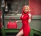 Charming young blonde with red dress, head scarf and bag. Sensual gorgeous young woman in red outfit with Marilyn Monroe look