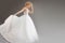 Charming young bride in luxurious wedding dress. Pretty girl in white, gray background, place for your text on the right