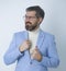 Charming young businessman unbuttoning his jacket while wearing a blue suit.