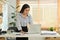 Charming young economist woman standing at working desk and analyzing financial market on laptop computer screen