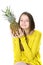 Charming young girl holds a large ripe pineapple in her hands.