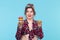 Charming young pin-up girl holding two donuts in her hands and one posing on a blue background. Concept benefits and