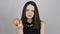Charming young woman eats a pink apple and smiles