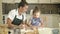 Charming young woman and her 5-6 year old daughter cook a dough together. Pleasant and rewarding pastime.