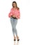 Charming young woman posing in studio in pink shirt and unbuttoned blue jeans