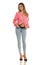 Charming young woman posing in studio in pink shirt and unbuttoned blue jeans