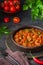 Chashushuli, thick beef stew in tomato sauce with sweet pepper, onion and spices in a clay bowl on a dark wooden background. Beef