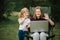 Chat online with family on laptop on picnic in nature. Homeschooling, freelance job. Mom and child. Mother work on Internet with