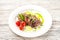 Chateaubriand in a restaurant close-up. Beef tenderloin steak with tomatoes on a white plate and copy space