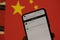 ChatGPT chat bot on smartphone screen and China flag in background. OpenAI chat bot artifical intelligence