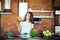 Chatty brunette woman playing with vegetables while talking on mobile phone on her modern kitchen