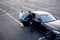 Chauffeur helps a businesswoman to get out of a car on parking lot