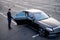 Chauffeur helps a businesswoman to get out of a car on parking lot