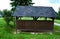 Cheap wooden pergola in the meadow serves as a shelter for the playground in the housing estate. flat roof, yellow wooden columns