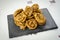 Chebakia moroccan pastries on a slate plate on a handmade tablecloth.