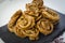 Chebakia moroccan pastries on a slate plate on a handmade tablecloth.